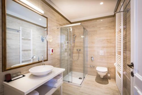 奥帕提亚Hotel Palace Bellevue - Liburnia的一间带水槽和玻璃淋浴的浴室