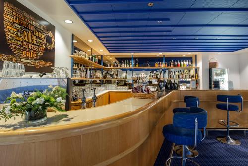 哈泽斯莱乌Hotel Norden的餐厅内带蓝色凳子的酒吧