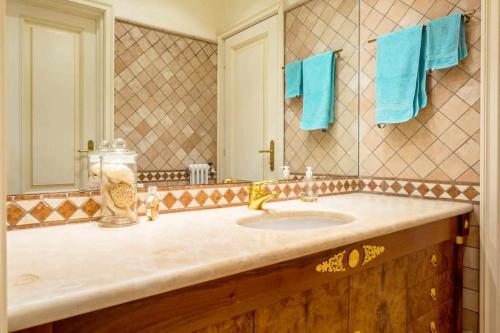 奥尔塔圣朱利奥LISOLA Appartamento con vista lago的浴室设有水槽、镜子和蓝色毛巾