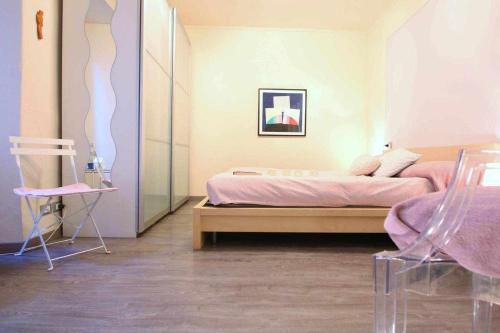 奥尔塔圣朱利奥LA PERLA piccolo appartamento in piazza的一间卧室配有一张床和一把椅子