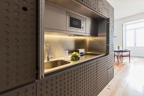 波尔图洛夫特普兹波那公寓式酒店的厨房配有水槽和微波炉