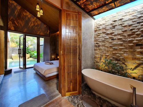 龙目岛库塔Batatu Villas的带浴缸的浴室和卧室