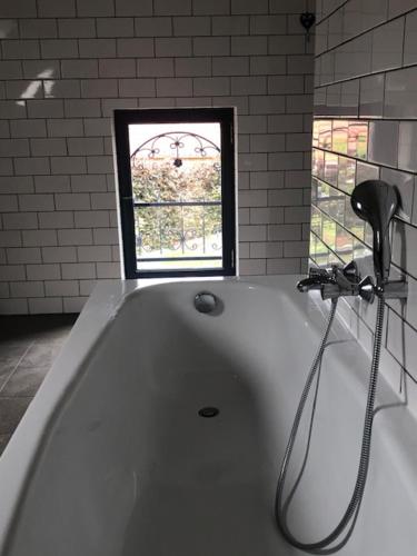 拉纳肯Hômage的带浴缸的浴室和窗户