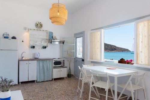 普拉提伊亚洛斯西弗诺斯Grandma's sifnos house的白色的厨房配有桌子,享有海景