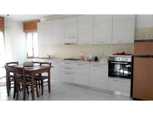 维拉普特祖Costa vacanze in low cost - IUN P2923的厨房配有白色橱柜和桌椅