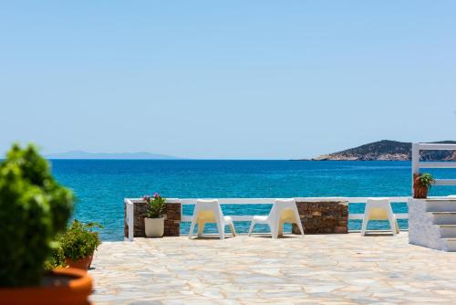 普拉提伊亚洛斯西弗诺斯Ammos Sifnos Village的俯瞰大海的庭院上摆放着一排白色椅子