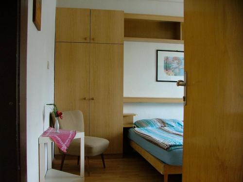 法克湖畔杜罗博拉赫Pension Weiss的一间卧室配有一张床、一把椅子和一张书桌