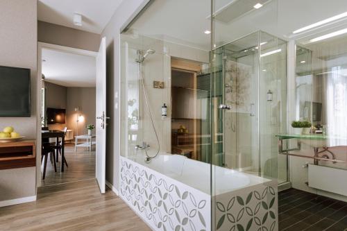 圣马丁娜穆里Hotel Terme Sveti Martin的带浴缸和玻璃淋浴间的浴室。