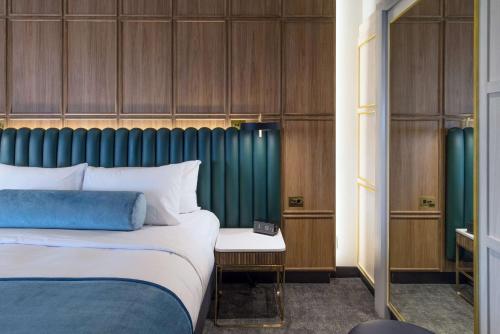 塔姆沃思Powerhouse Hotel Tamworth by Rydges的一间卧室配有一张床和一个绿色床头板