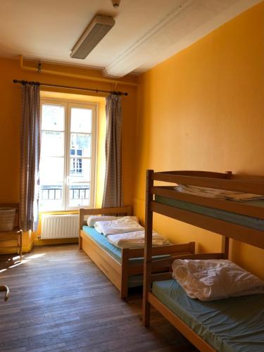 贝叶Hostellerie des Grands Chapeaux的客房设有两张双层床和一扇窗户。
