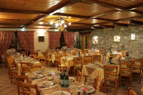 查兰德圣安塞尔尼里山酒店的一间大餐厅,配有桌椅和瓶装葡萄酒
