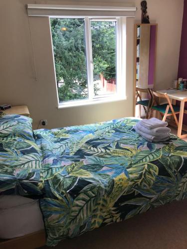 诺里奇诺维奇民宿的卧室里一张带五颜六色棉被的床,卧室里设有窗户