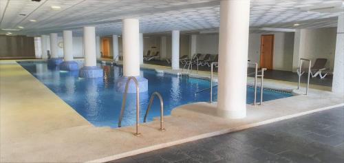 比卡尔La envia golf的一座建筑物内一个带柱子和椅子的游泳池