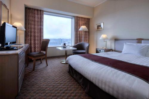 四日市Miyako Hotel Yokkaichi的酒店客房设有一张床和一个大窗户