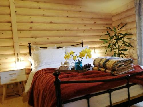 雷文格拉斯Ravenglass Log Cabin的一间卧室配有一张木墙床
