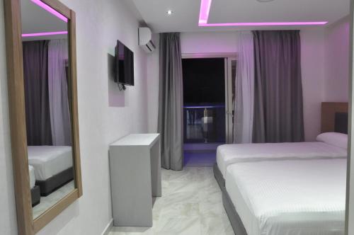 米迪克Hôtel laluna bay的酒店客房,设有两张床和镜子