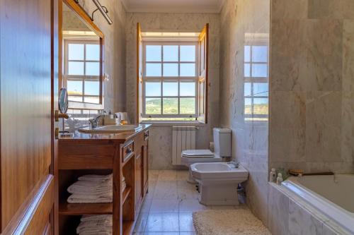 弗雷舒德埃什帕达阿辛塔Casa da Pergula的浴室配有盥洗盆、卫生间和浴缸。