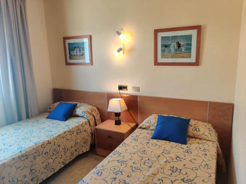 阿尔库迪亚港Mar Blau的酒店客房 - 带两张带蓝色枕头的床