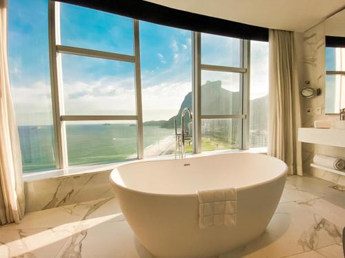 里约热内卢Hotel Nacional Rio de Janeiro - OFICIAL的带浴缸的浴室和大窗户