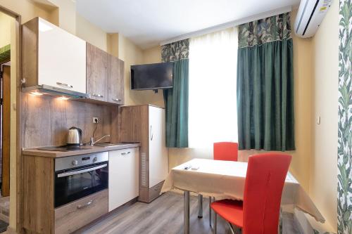 瓦尔纳BOLERO Suites的一间带桌子和红色椅子的小厨房