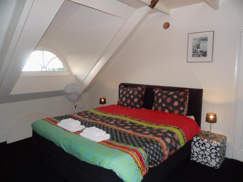 KollumerpompAppartement Greidesicht Kollumerpomp的一间卧室配有一张带红色毯子的床