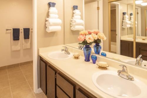里诺Thunderbird Resort Club的浴室设有两个水槽和花瓶