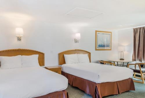 海恩尼斯海恩尼斯美国最佳价值套房汽车旅馆的酒店客房设有两张床和一张桌子。