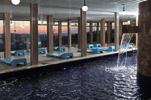 康塞高伊比蒂波卡Hotel Alpha Ville Chalés的一座建筑中间的游泳池,有一个喷泉