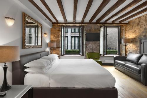 蒙特利尔蒙特利尔史诗酒店的卧室配有白色的床和沙发