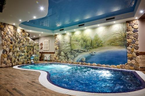 陶里亚蒂Lovchiy Plus的一个带壁画的酒店客房内的大型游泳池