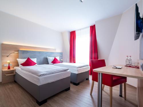 勒沃库森Landhotel Fettehenne的一间卧室配有两张床、一张桌子和一张桌子