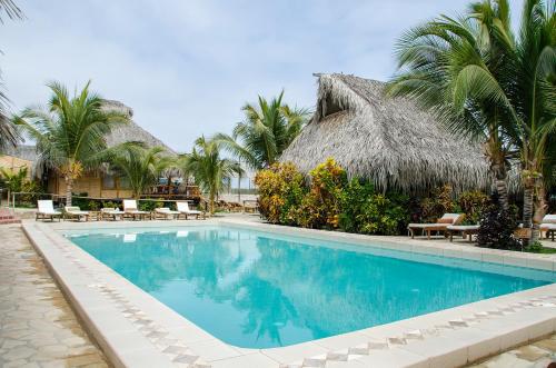 维加伊托Las Cabañas de Antica的棕榈树度假村前的游泳池