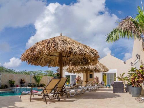棕榈滩金色别墅式酒店的一组椅子和一把大草伞