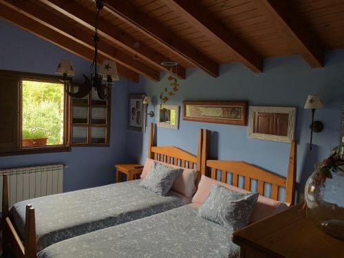 PiloñaLa Milonga的一间卧室设有两张床,拥有蓝色的墙壁。