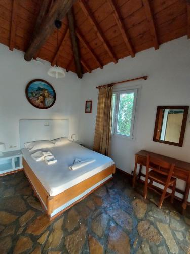 KoumeikaBeautiful house wiht sea view in Samos Island的一间卧室配有一张大床和一张桌子