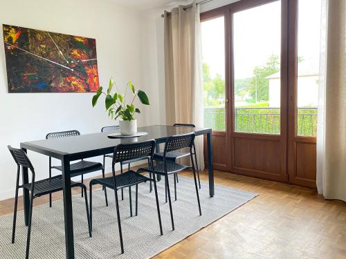 La BonnevilleMaison chaleureuse avec un grand jardin的一间用餐室,配有黑色的桌子和椅子