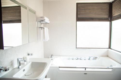 奈瓦沙Elmer Resort & Spa Naivasha的白色的浴室设有水槽和镜子