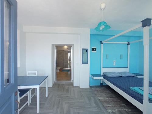 OlymposAnemos Guest House Karpathos的一间卧室设有一张床和蓝色的墙壁