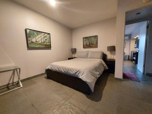 洛杉矶比佛利山银盒旅馆的卧室配有一张床,墙上挂有两张照片