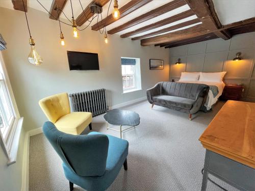 戴德姆The Marlborough Dedham的一间卧室配有一张床、一张沙发和椅子