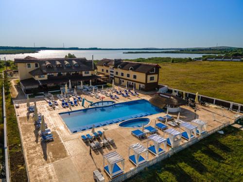 穆里吉奥尔Pensiunea Danubiu的享有带椅子的大型游泳池和度假村的空中景致