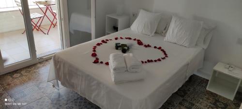 蓬塔翁布里亚VACACIONES DUQUE GALEY的白色的床,心由玫瑰制成