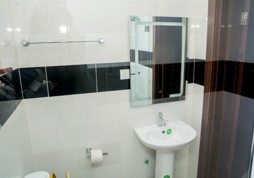 拉各斯Presken Hotel @Oniru的白色的浴室设有水槽和镜子