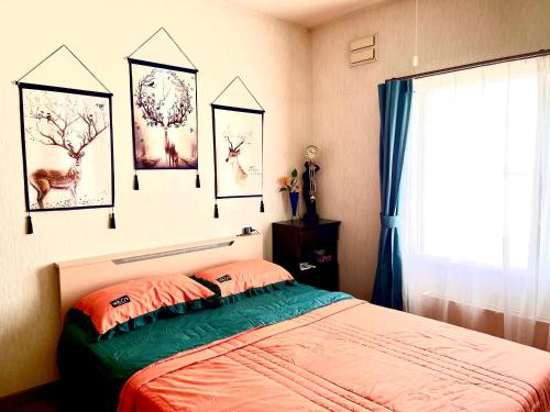 富良野PENSION YunShuiYao雲水瑶民宿的一间卧室配有一张床,墙上挂着一些图片