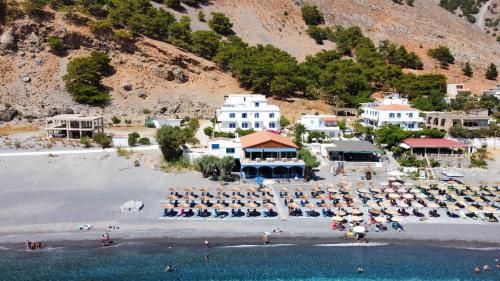 阿吉亚努美利Agia Roumeli Hotel的享有海滩的空中景致,配有椅子和遮阳伞