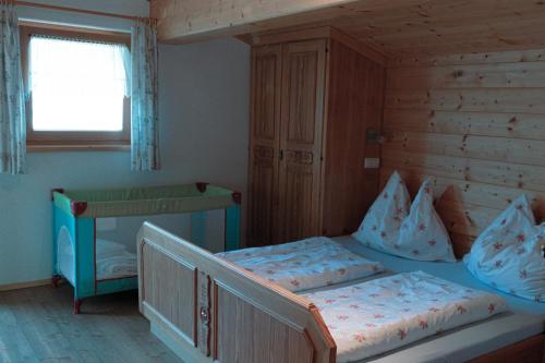 皮森多夫恩特霍尔兹霍夫农家乐的一间卧室设有两张单人床和一个窗户。