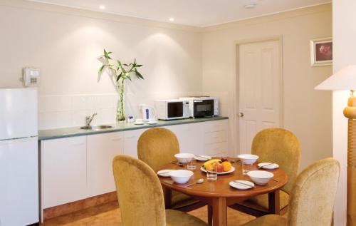 黄金海岸皇家森林度假村的厨房以及带桌椅的用餐室。