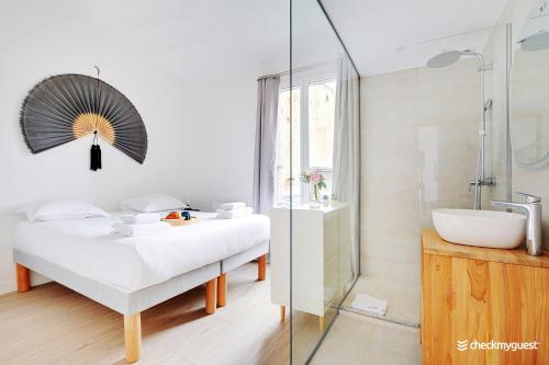 巴黎CMG Gaite - Montparnasse的一间带床、水槽和淋浴的浴室