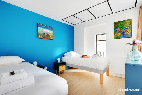 巴黎CMG Gaite - Montparnasse的一间设有两张床和蓝色墙壁的客房