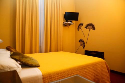 特罗法雷洛德雷马诺列达米安公园酒店的一间卧室配有一张黄色床单和鲜花的床